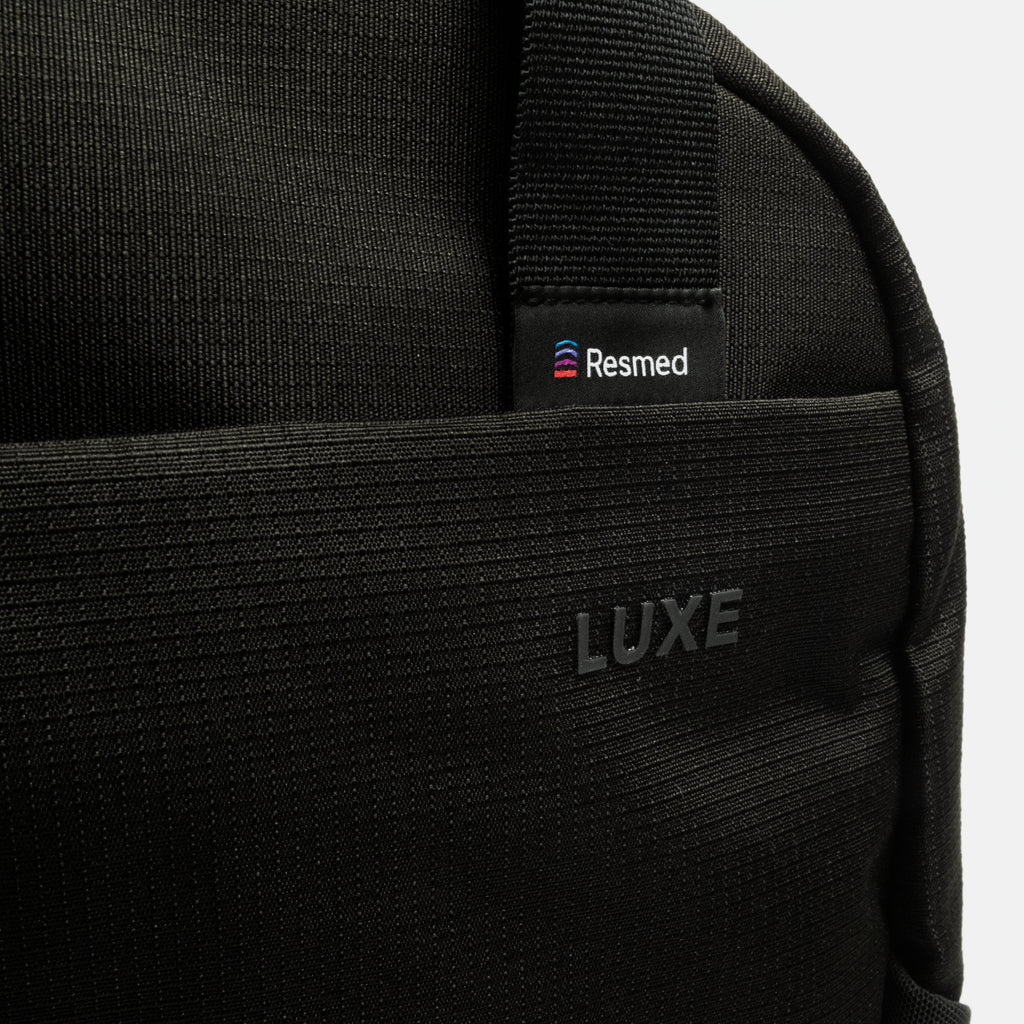 Close up of the black luxe backpack, zooming in on the resmed logo