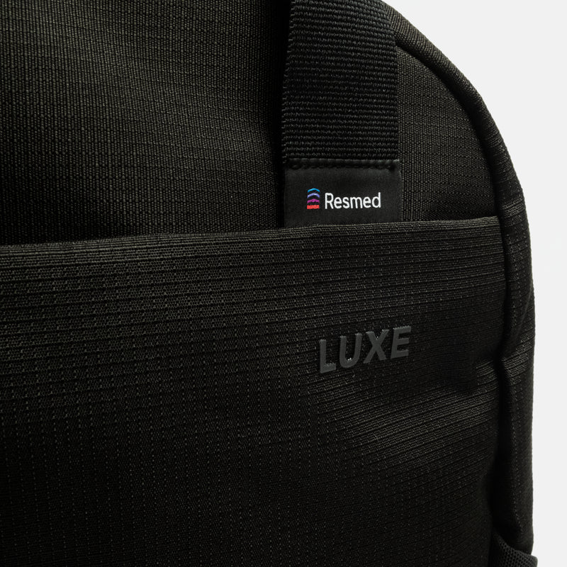 Close up of the black luxe backpack, zooming in on the resmed logo