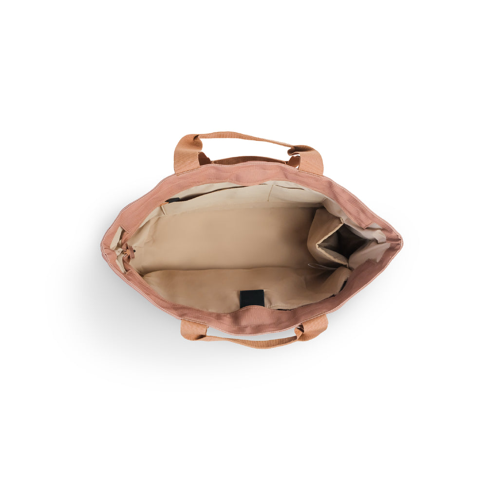 Luxe tote bag An overhead view of a dusty rose canvas tote bag showing its beige interior lining and top handles against a white background.