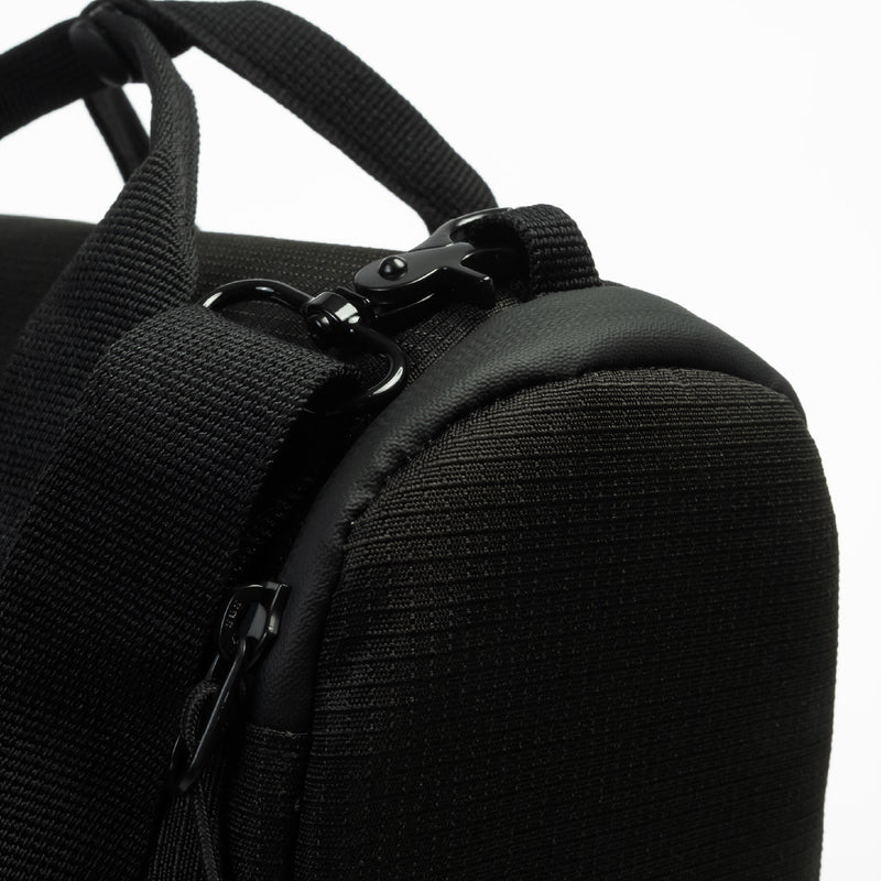 Close-up of a black textured CPAP insert with a black zipper, black webbing strap, and black metal clip hardware against a white background.